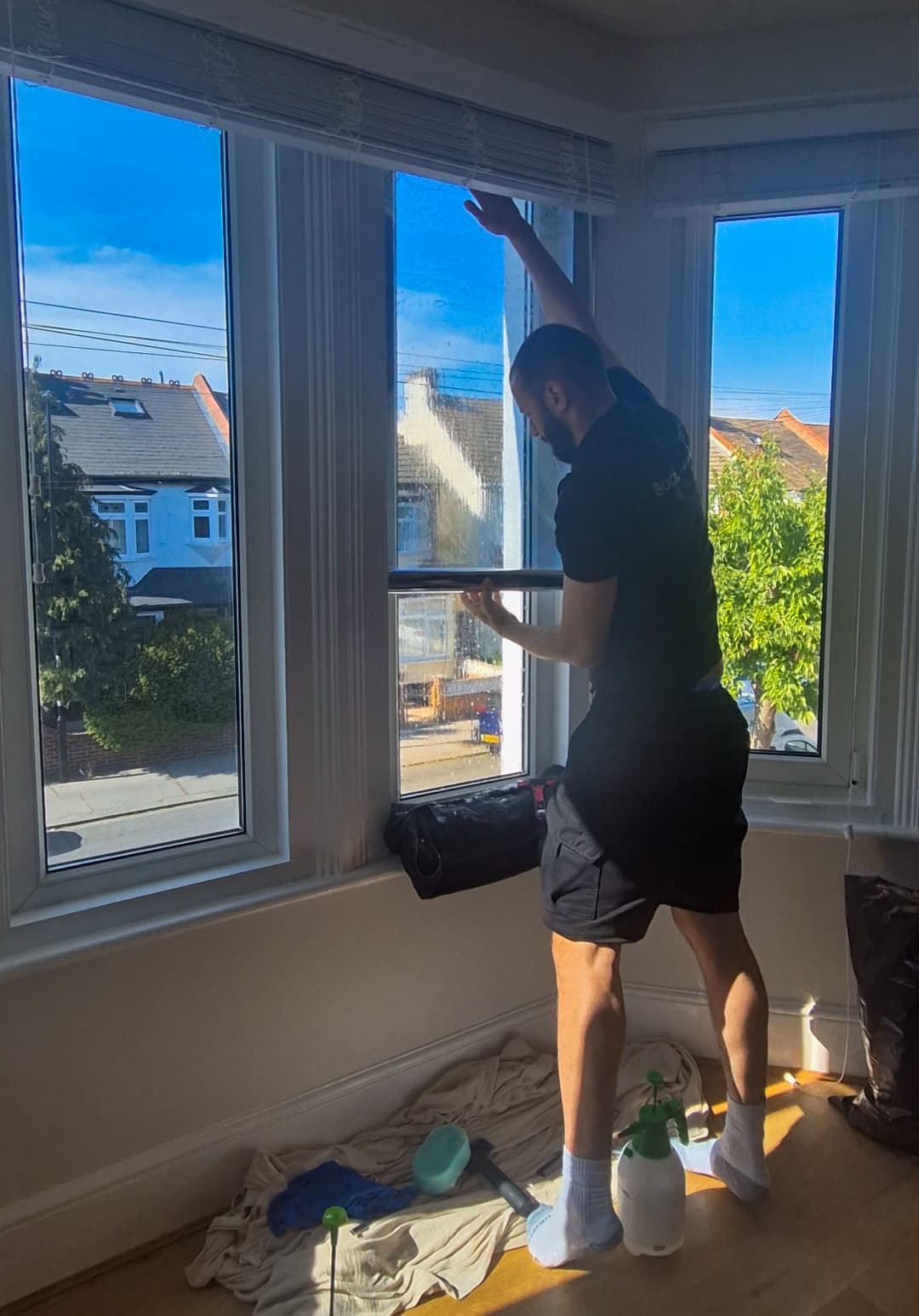 Professional flat-glass installer fitting premium Silver Reflective window film to a residential bay window in Reading