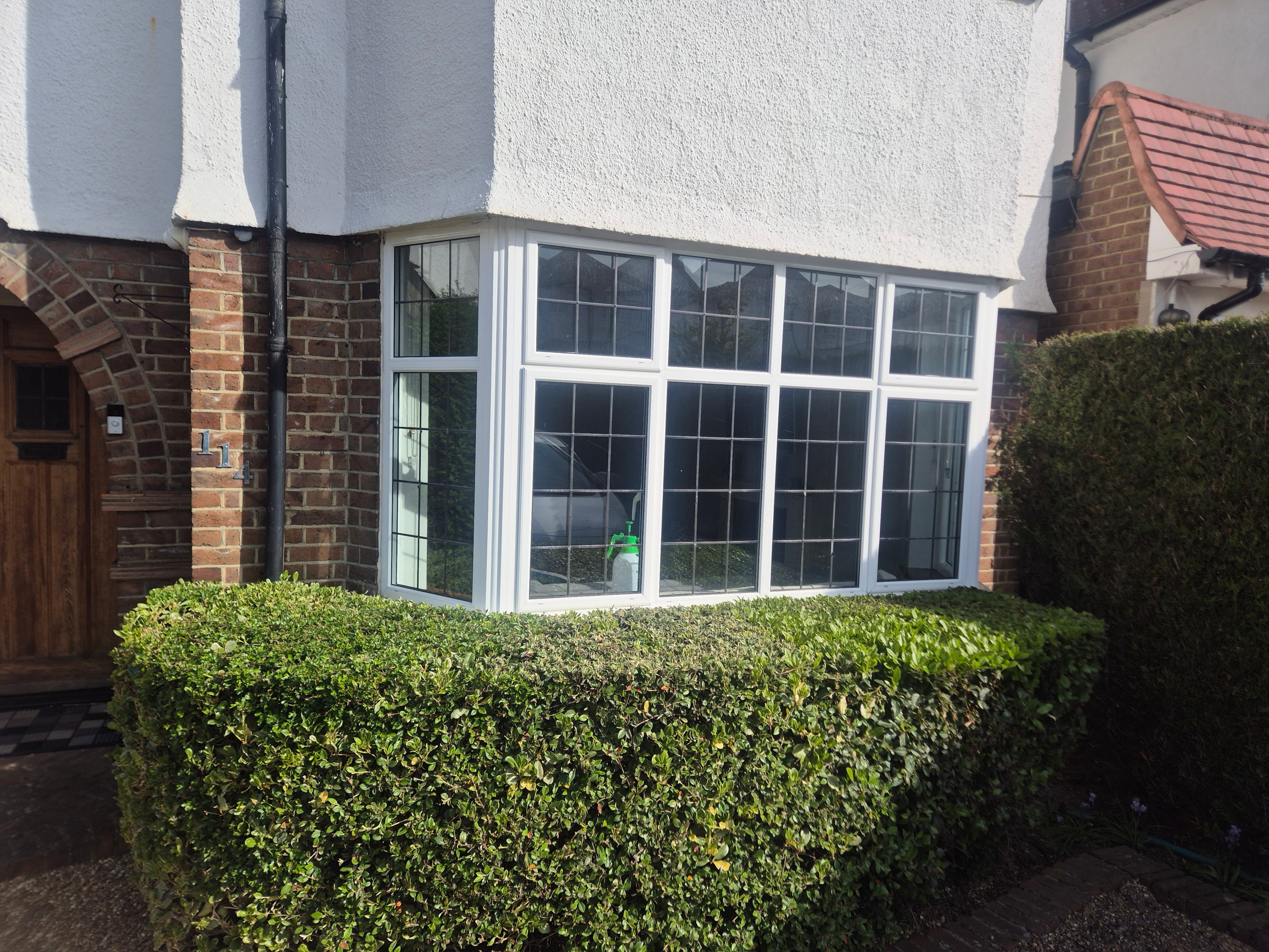 Exterior view of a residential bay window in High Wycombe before window film installation, showing clear glass with no privacy from the street