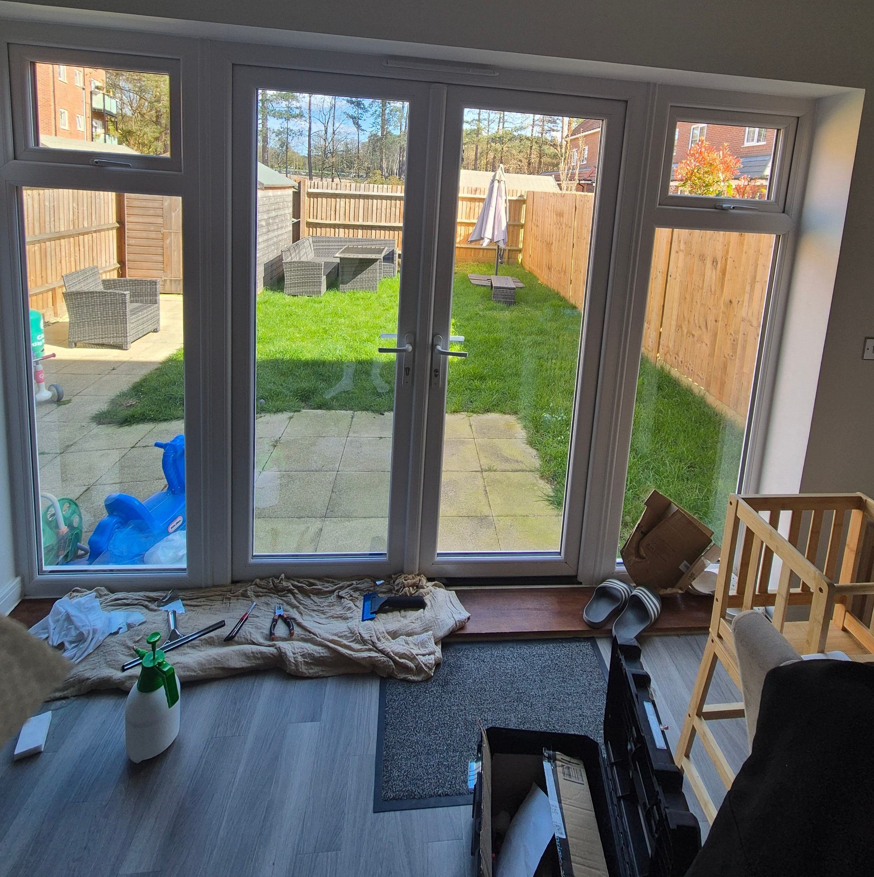 Professional window film installation in progress inside a Staines kitchen, with dust sheets, cleaning tools and preparation work visible before applying solar and UV protection film.