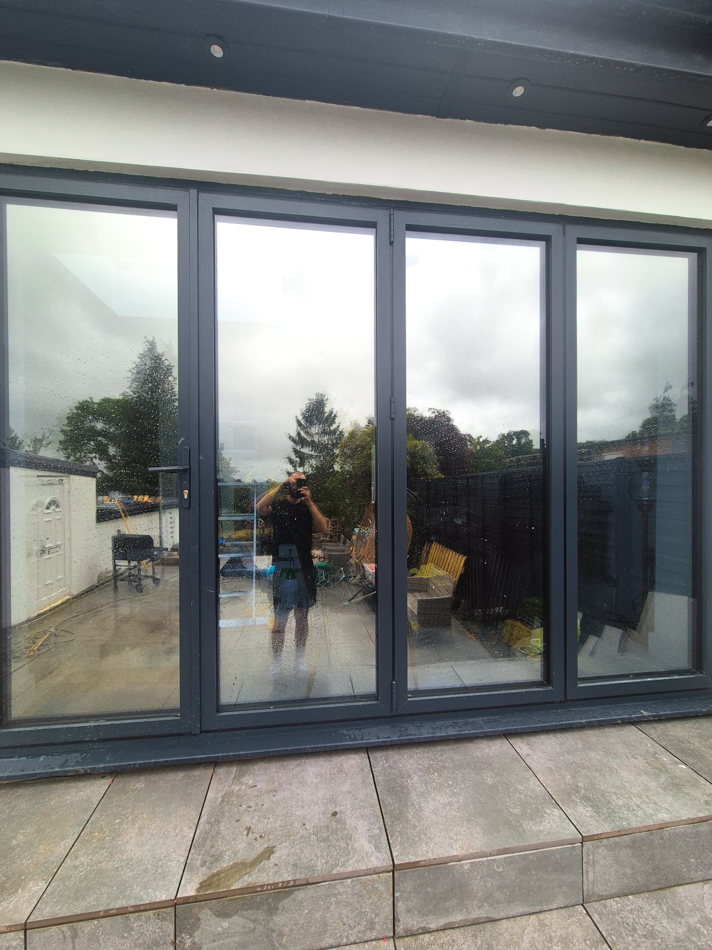 Exterior view of the completed bifold door installation in Uxbridge, showing a clean mirror‑like finish that provides full daytime privacy and eliminates glare.